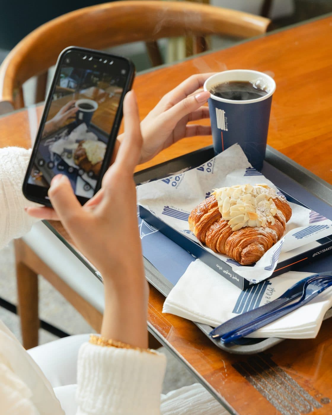 Almond croissant and coffee on a table at DOT